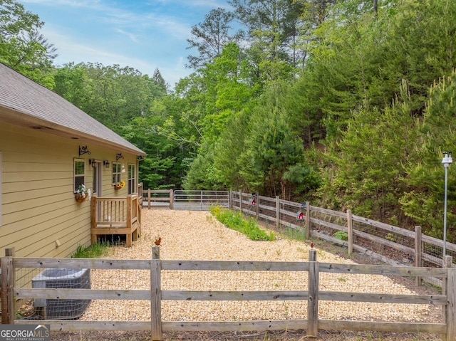 view of yard with a view of trees and cooling unit