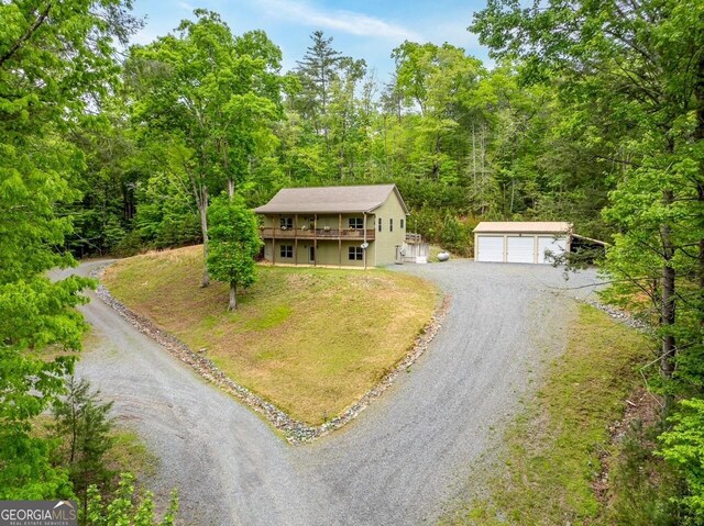 102 Waleska Ln Unit 3, Ellijay, GA 30540 - view of front facade with an outdoor structure, a detached garage, a wooded view, a front lawn, and a wooden deck