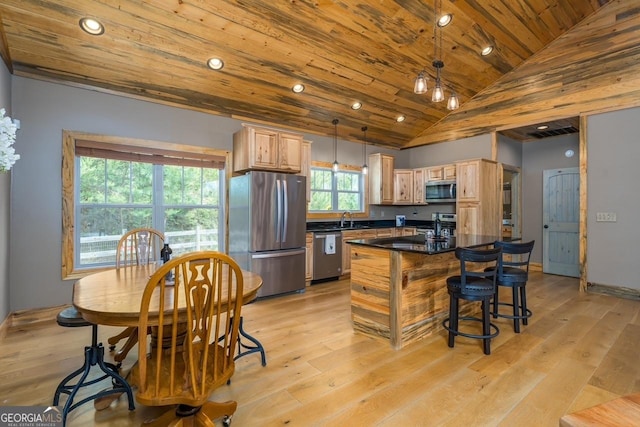 kitchen featuring dark countertops, light brown cabinetry, a sink, stainless steel appliances, and recessed lighting