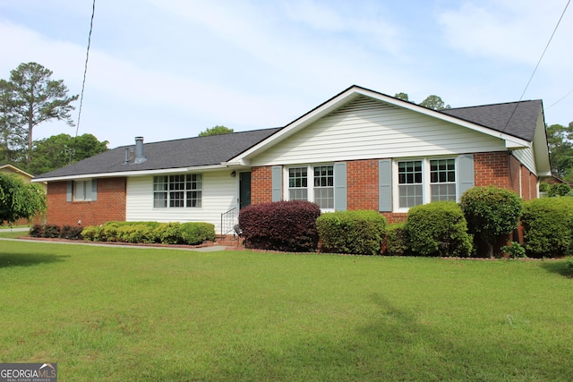 ranch-style house featuring brick siding, roof with shingles, and a front yard