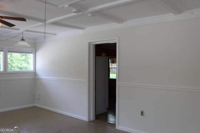 empty room featuring a ceiling fan, baseboards, beam ceiling, and coffered ceiling