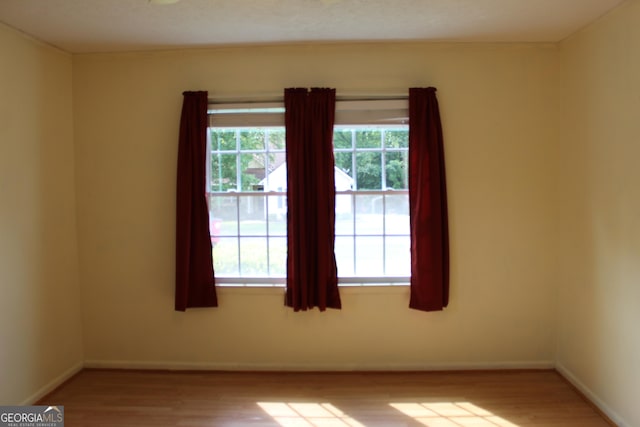empty room with baseboards and wood finished floors