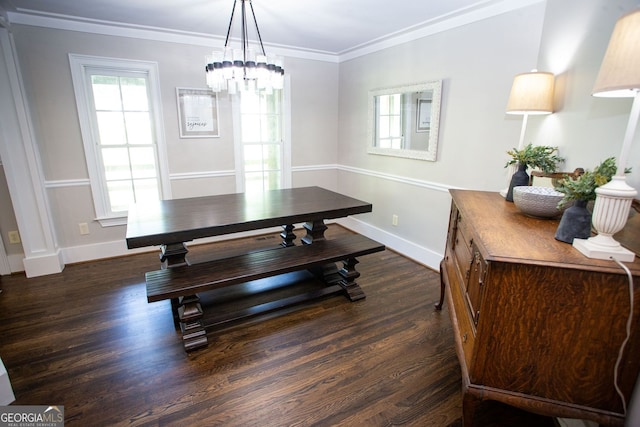 dining area featuring crown molding, baseboards, wood finished floors, and a chandelier
