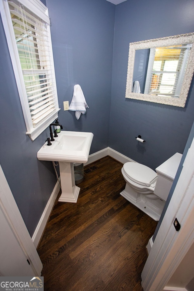 bathroom featuring toilet, baseboards, and wood finished floors