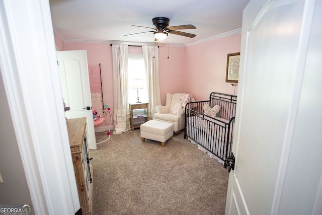bedroom with crown molding, carpet, ceiling fan, and a nursery area
