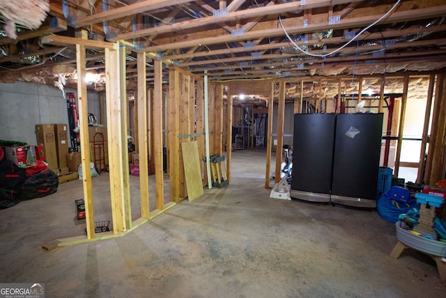 unfinished basement featuring freestanding refrigerator