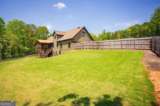 view of yard featuring stairway, a fenced backyard, and a sunroom
