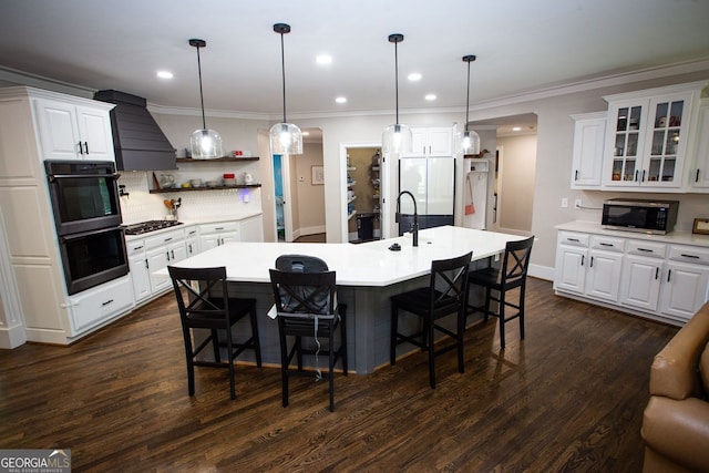 kitchen with dobule oven black, stainless steel microwave, premium range hood, and a breakfast bar