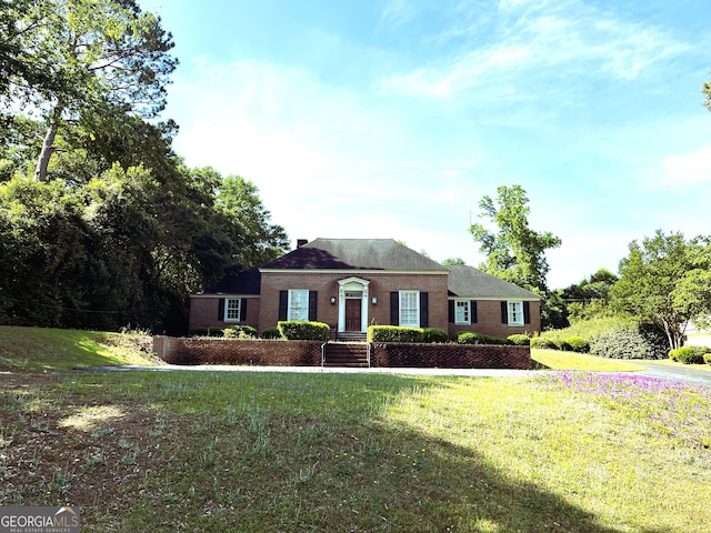 view of front of house featuring brick siding and a front yard