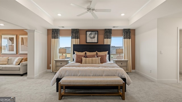 bedroom with baseboards, ornamental molding, a tray ceiling, and light carpet
