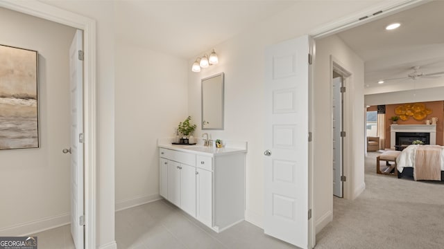 bathroom with a glass covered fireplace, baseboards, recessed lighting, a ceiling fan, and ensuite bath