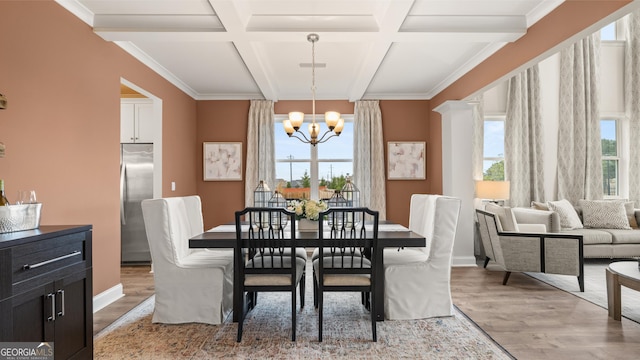 dining area featuring light wood-style flooring, coffered ceiling, a chandelier, and beamed ceiling