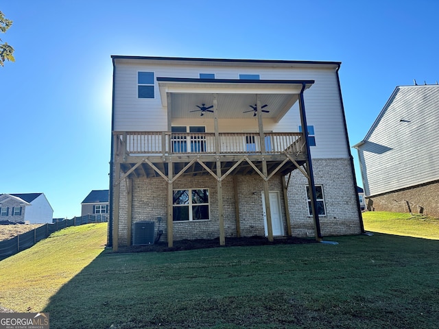 back of property with central AC, a wooden deck, fence, a ceiling fan, and a lawn