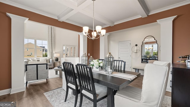 dining space with beamed ceiling, wood finished floors, and a chandelier