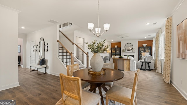 dining space with recessed lighting, ornamental molding, wood finished floors, and stairway