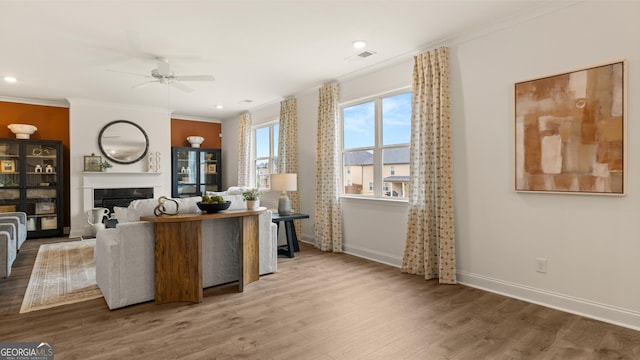 living room with baseboards, ornamental molding, and ceiling fan