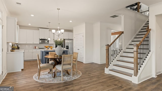 dining room with baseboards, stairs, a chandelier, and visible vents