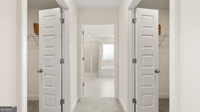hallway with baseboards and carpet
