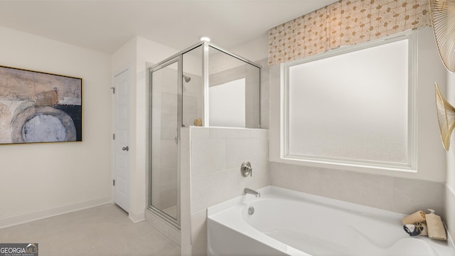 bathroom featuring tile patterned flooring, a bath, and a stall shower