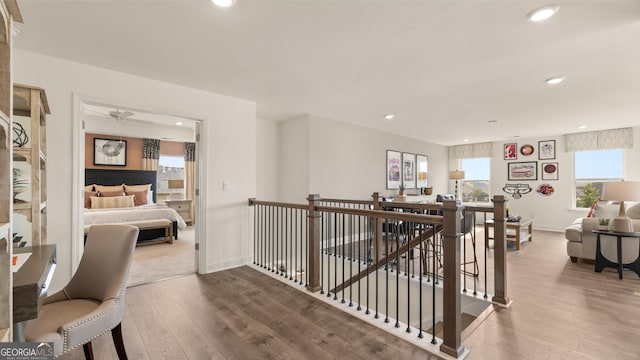hallway with recessed lighting, baseboards, an upstairs landing, and hardwood / wood-style floors