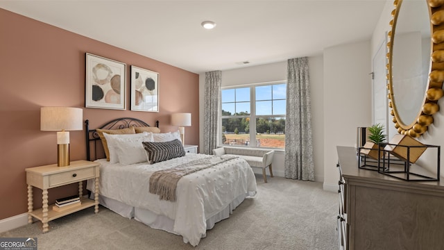 bedroom featuring visible vents, baseboards, and light carpet