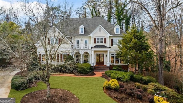 view of front of property featuring a balcony and a front yard