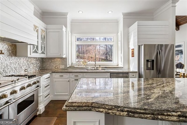 kitchen featuring decorative backsplash, dark wood-type flooring, a sink, dark stone countertops, and stainless steel appliances