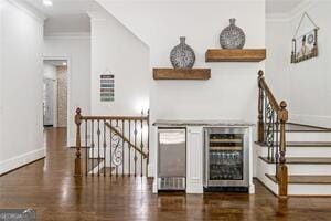 bar featuring crown molding, a dry bar, baseboards, and wine cooler