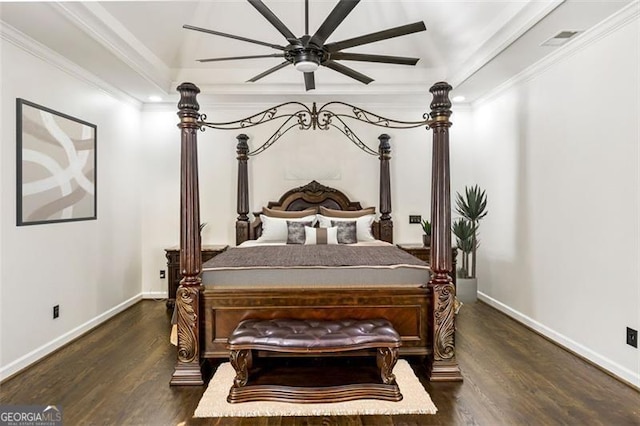 bedroom featuring crown molding, visible vents, lofted ceiling, wood finished floors, and baseboards
