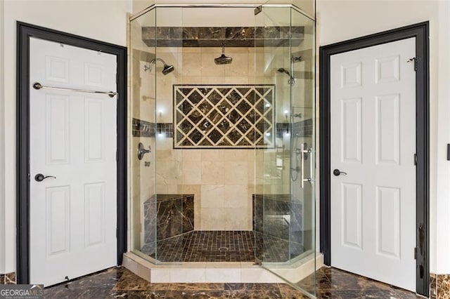 bathroom featuring marble finish floor and a stall shower