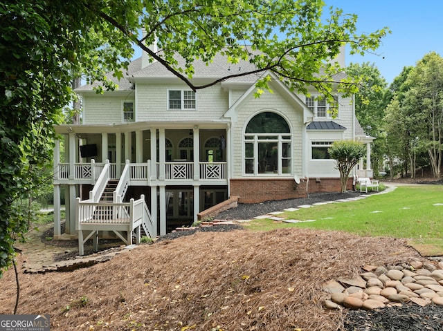 rear view of house featuring stairs, roof with shingles, and a yard