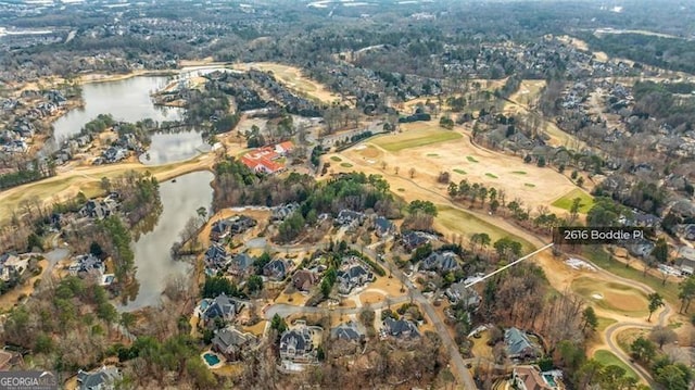 birds eye view of property with a water view and view of golf course