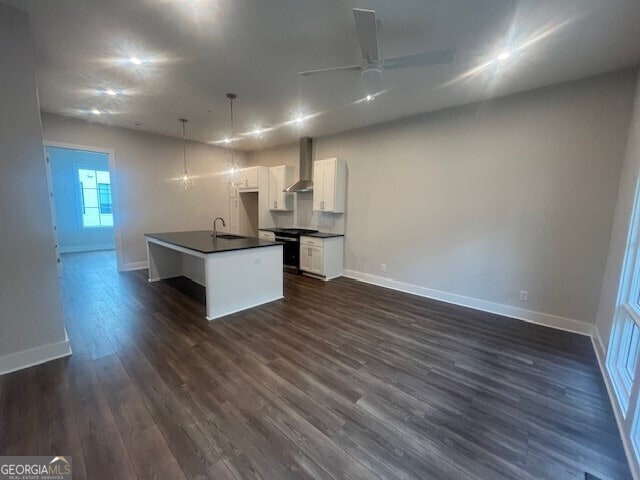 128 Bert Ln SE Unit 167, Atlanta, GA 30316 - kitchen with wall chimney range hood, dark countertops, a sink, and baseboards