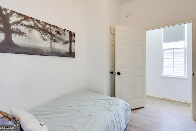 bedroom with light wood-style flooring and baseboards