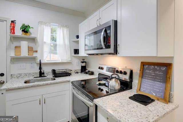 kitchen featuring open shelves, appliances with stainless steel finishes, a sink, and white cabinetry