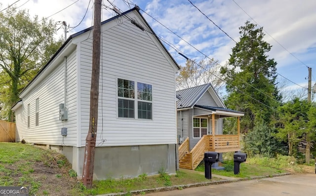 view of side of home featuring crawl space and stairway