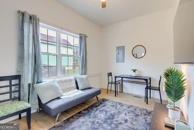 living area featuring electric panel and wood finished floors