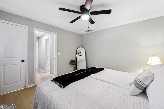 bedroom with visible vents, light wood-style flooring, ceiling fan, and baseboards