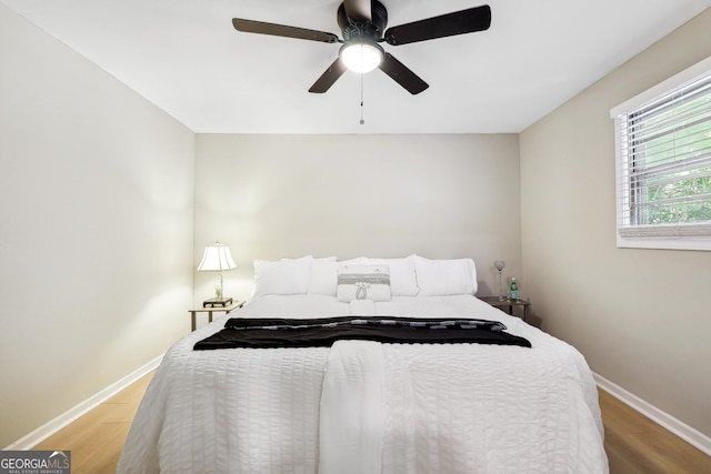 bedroom featuring baseboards, ceiling fan, and light wood finished floors