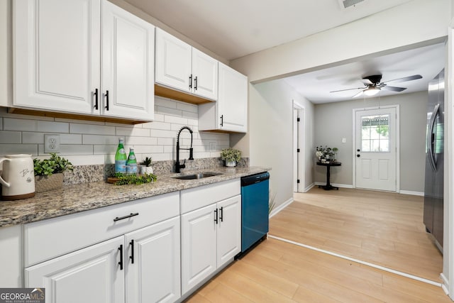 kitchen featuring decorative backsplash, baseboards, white cabinetry, a sink, and dishwasher