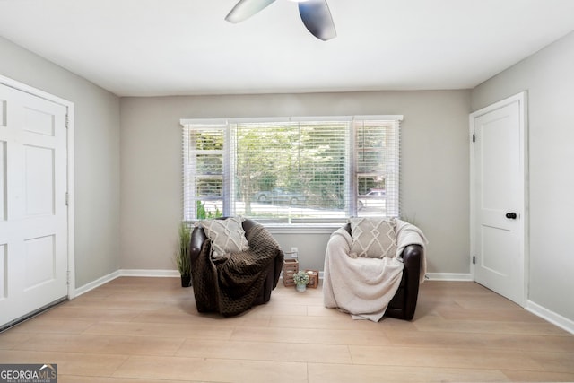sitting room featuring a ceiling fan, baseboards, and wood finished floors