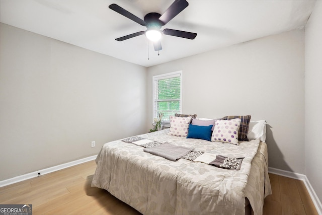 bedroom with baseboards, ceiling fan, and wood finished floors
