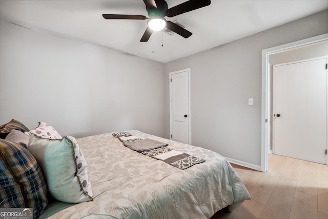 bedroom featuring baseboards, a ceiling fan, and light wood-style flooring