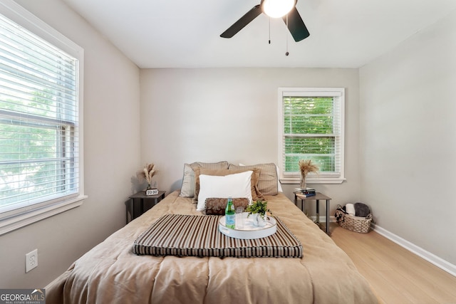 bedroom featuring baseboards, a ceiling fan, and wood finished floors