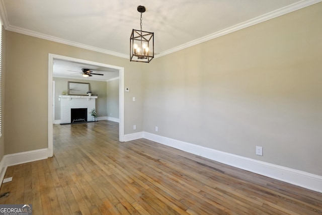 785 Alice St, Forest Park, GA 30297 - spare room with ornamental molding, a fireplace, baseboards, hardwood / wood-style flooring, and ceiling fan with notable chandelier
