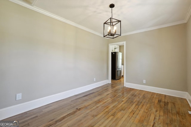 785 Alice St, Forest Park, GA 30297 - empty room with wood-type flooring, ornamental molding, baseboards, and an inviting chandelier