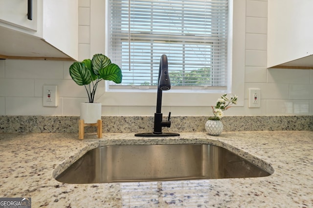 785 Alice St, Forest Park, GA 30297 - details with a sink, light stone counters, tasteful backsplash, and white cabinetry