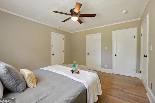 785 Alice St, Forest Park, GA 30297 - bedroom with crown molding, baseboards, a textured ceiling, a ceiling fan, and light wood-style flooring