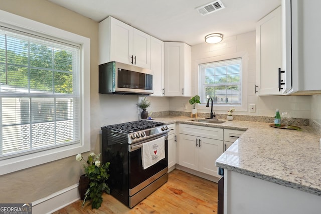 785 Alice St, Forest Park, GA 30297 - kitchen with a sink, appliances with stainless steel finishes, white cabinetry, and visible vents