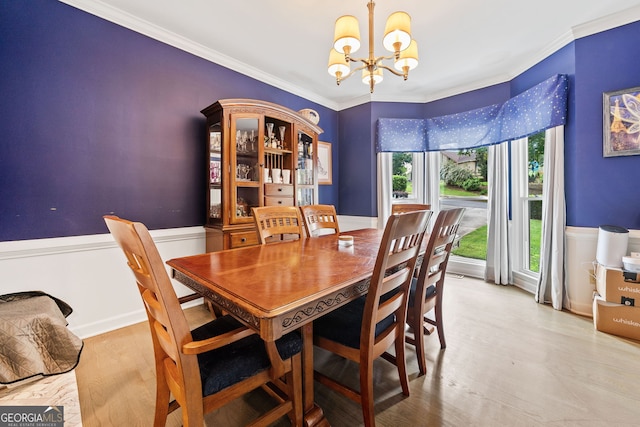 dining space with crown molding, wood finished floors, and a chandelier
